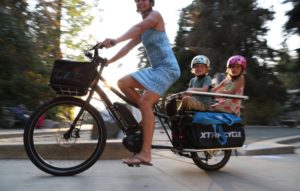 woman riding swoop x1 bicycle with children in the back platform